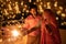 Happy young indian couple celebrating diwali festival both holding sparkler in hand and wearing traditional wear or ethnic outfit