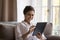 Happy young Indian tablet user woman resting on couch