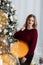 Happy young lady with long hair gifts by the fireplace near the Christmas tree