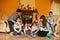 Happy young large family at home by a fireplace in warm living room on winter day