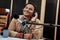 Happy young male radio host looking aside while broadcasting in studio, using microphone and headphones