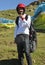 A happy young male tourist wearing helmet and harness for taking paragliding flight.