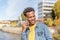 Happy young man with afro hair and denim jacket talks happily on his mobile phone