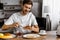 Happy young man applying jam onto toast