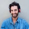 Happy young man with beard listening to music with headphones