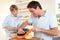 Happy young man with boy peeling vegetables