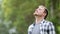 Happy young man breathing deep outdoors