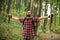 Happy young man enjoying a perfect peaceful moment during hike through forest. Arms outstretched