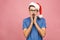 Happy young man expressing emotions in good christmas day. Studio portrait of amazed european guy wears santa claus hat