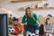 happy young man in green fan t-shirt celebrating while his upset friends sitting behind on sofa during watch of soccer match