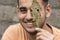 Happy young man holding a ruin leaf in front of face at outdoor