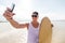 Happy young man with skimboard on summer beach