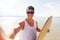 Happy young man with skimboard on summer beach