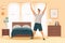 A happy young man stretches in his bedroom after waking up. He is smiling and excited to start his day, doing morning gymnastics
