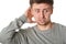 Happy young man with uncertain puzzled expression, on gray background