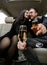 Happy young man and woman drinking champagne in car