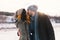 A happy young man and woman kissing in winter enjoying life and