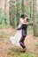 Happy young married wedding couple on walk in pine forest around trees. Groom circling bride in beautiful white dress