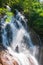 Happy young men relaxing under waterfall in nature. Summer season. Long exposure. Khao Lak, Thailand. Nature Therapy