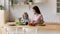 Happy young mother cooking salad with small daughter