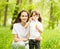 Happy young mother and her daughter blowing soap bubbles in park