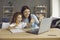 Happy young mother and her funny little daughter have an online meeting with relatives.