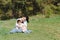 Happy young mother is playing with her baby in a park on a green lawn. Happiness and harmony of family life. Great family vacation