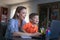 Happy young mother and son joking at laptop in home office