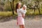 Happy young mother and two-year-old girl whirling. people in white clothes spring