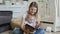 Happy young mother watching photographs in family album with her baby son