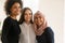 Happy young Muslim professional woman standing close with female colleagues