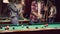 Happy young people enjoying billiard game together