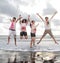 Happy young people jumping in a beach in summer with slow motion and blurry concept