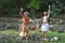 Happy young Polynesian Cook Islander couple dancing in a ancient