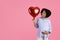 Happy young pregnant african american curly woman in casual with big belly hold heart balloon