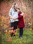 Happy young pregnant mother with daughter in autumn park