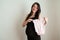 happy young pregnant woman prepares clothing item bodysuit for the newborn baby girl. happiness pregnacy concept