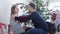 Happy young pretty couple sit near beautiful decorated Christmas tree. Husband gives a gift box to his pregnant wife