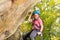 Happy young rock climber in helmet abseiling