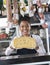 Happy Young Saleswoman Holding Cheese At Counter