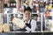 Happy Young Saleswoman Holding Cheese At Counter