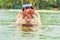 Happy young scuba diver holding sea star, smiling, looking at camera