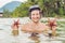 Happy young scuba diver holding sea star, smiling, looking at camera