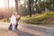 Happy young single mother taking a walk in a park with her toddler daughter. Family smiling and having fun