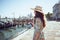 Happy young solo traveller woman in floral dress sightseeing