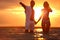 Happy young  spending time together on sea beach at sunset