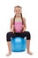 Happy young sporty girl sitting on large gymnastic rubber ball