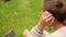 Happy young student sitting on grass using laptop