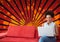 Happy young student woman using a computer against red, black and orange splattered background