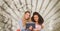 Happy young students holding a tablet against brown and white splattered background